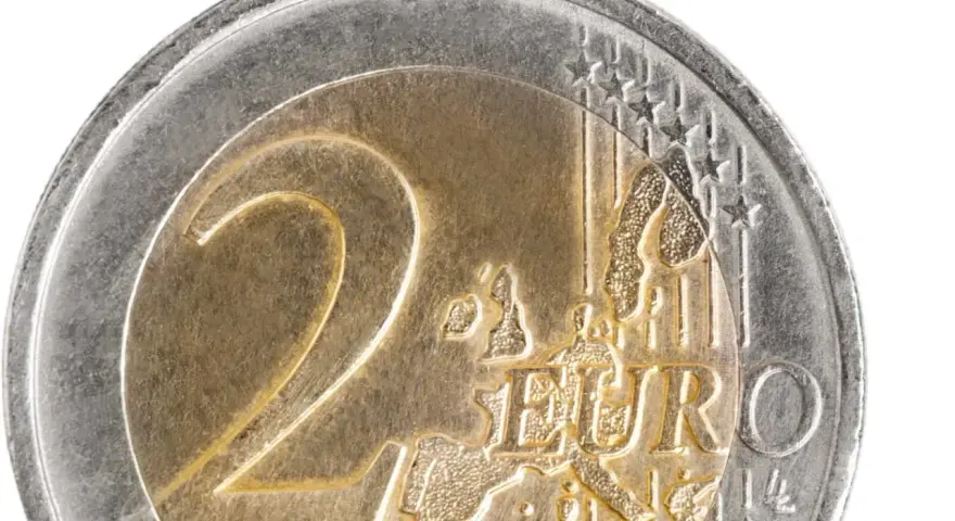 Gros plan d'une pièce de 2 euros commémorative. Le chiffre "2" est bien visible, ainsi que le mot "EURO" et une carte de l'Europe.