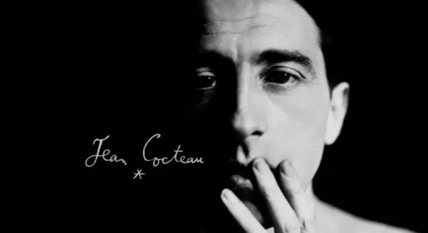 Primo piano di un volto illuminato da un lato, con la firma "Jean Cocteau" in corsivo. Un'immagine evocativa dei suoi film.