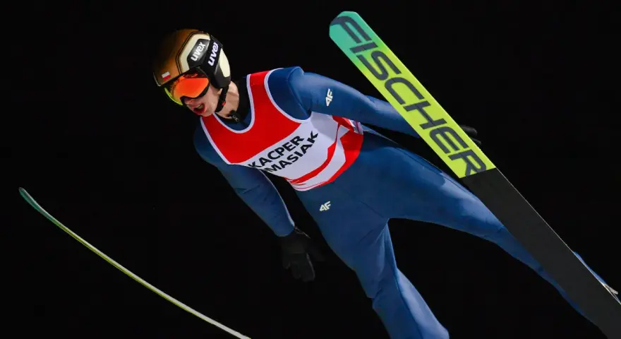 Skoczek narciarski w locie, przygotowujący się do Mistrzostw Świata Juniorów w Skokach Narciarskich 2026.