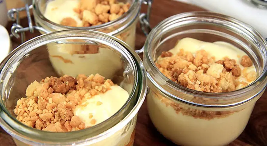 Tre små glasburkar med len vit chokladmousse toppad med smulig crumble. Perfekt för en söt stund.