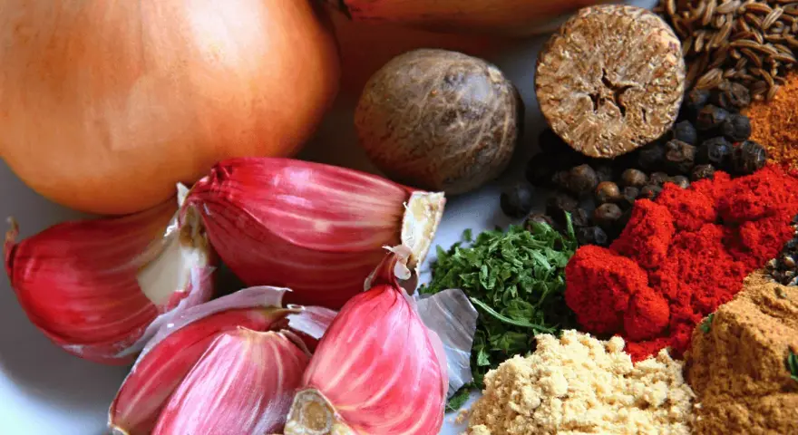 Cebollas, ajos rosados y especias como pimentón y comino, algunos de los alimentos ricos en quercetina para una dieta saludable.