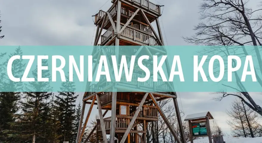 Drewniana wieża widokowa na szczycie Czerniawska Kopa, otoczona zimowym lasem.