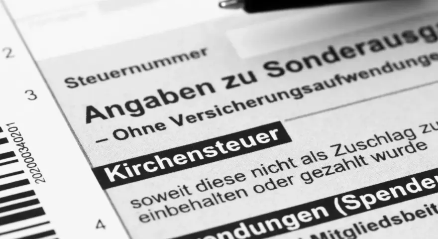 Steuerformular mit dem Feld "Kirchensteuer". Ein Stift liegt bereit, um Angaben zu machen, die die Kappung der Kirchensteuer betreffen könnten.
