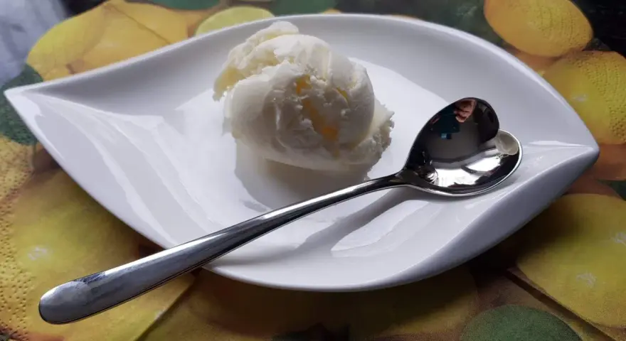 Cremiges Batida de Coco Eis auf einem Blatt-Teller, bereit zum Genießen.