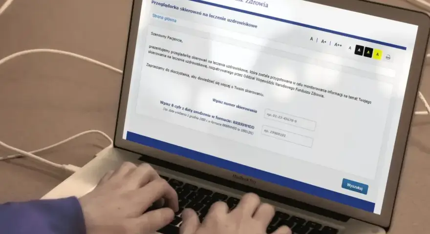 Laptop z otwartą stroną NFZ do wyszukiwania skierowań na leczenie uzdrowiskowe.