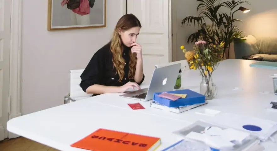 Junge Frau mit guten EDV-Kenntnissen arbeitet konzentriert an ihrem Laptop in einem hellen Büro.