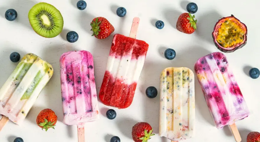 Fruchteis am Stiel mit Beeren, Kiwi und Maracuja. Welches Eis hat am wenigsten Zucker? Die bunten Eis am Stiel sehen lecker aus.