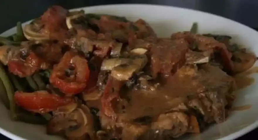 Un savoureux sauté de veau tomates champignons, servi avec des haricots verts. Un plat réconfortant et plein de saveurs.