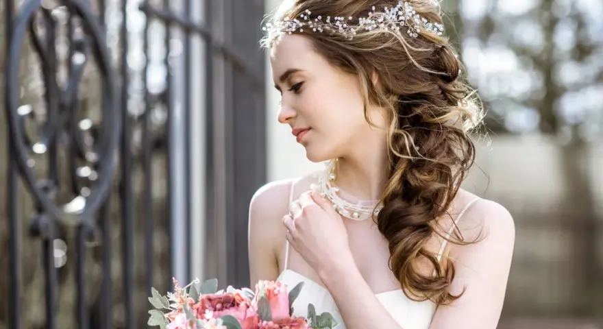 Upięta fryzura glamour z ozdobami z pereł i kryształków, delikatny bukiet róż i piwonii.