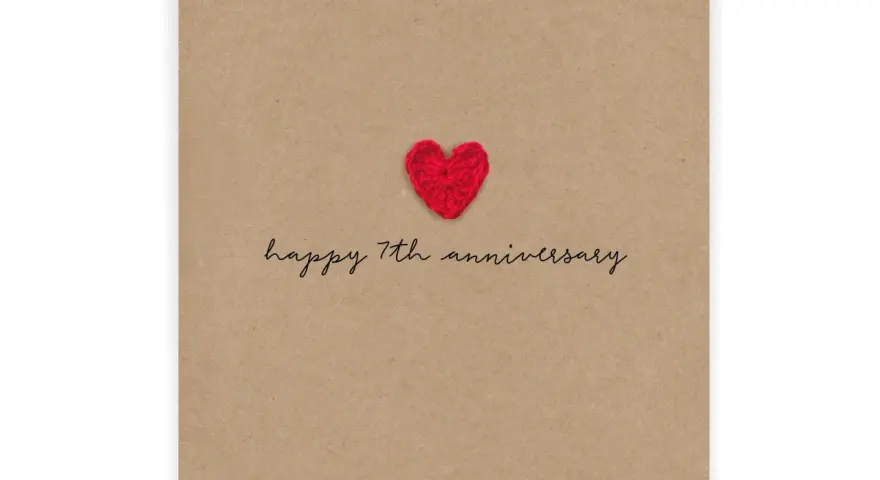 Czerwone, szydełkowe serduszko na brązowej kartce z napisem "happy 7th anniversary". Idealne na 7 rocznicę ślubu.