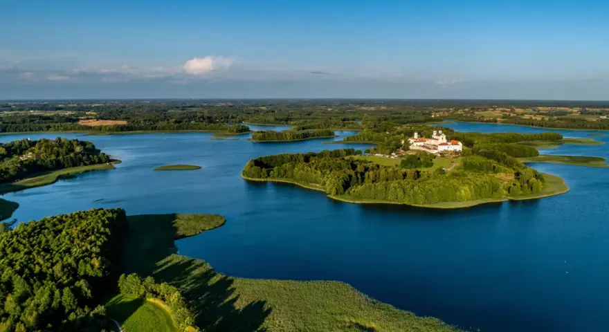 Malowniczy wschód Polski nad jeziorem, z wyspą i klasztorem.