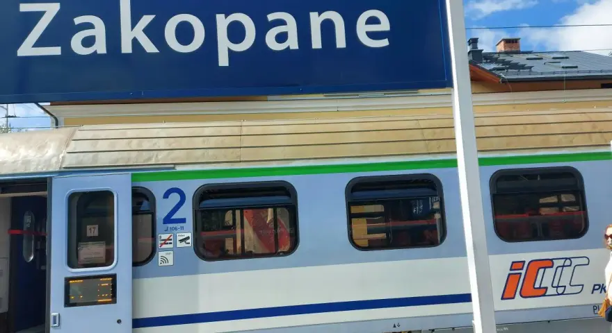 Niebieski znak "Zakopane" nad pociągiem PKP Intercity z numerem wagonu 2.