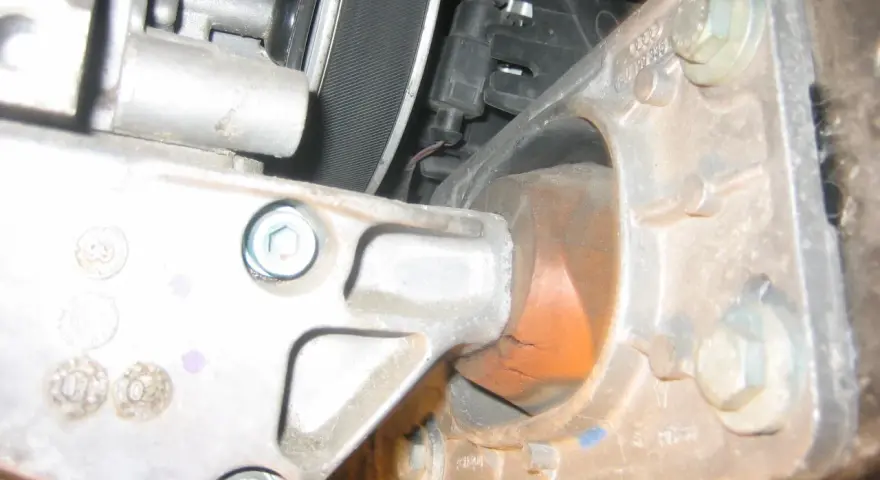 Zużyta poduszka silnika w Audi p1577. Widoczne pęknięcia gumy i metalowe elementy mocujące.