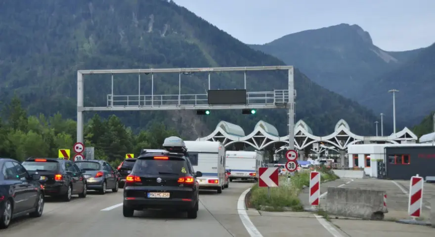 Korki na autostradzie przed punktem poboru opłat z widokiem na góry.