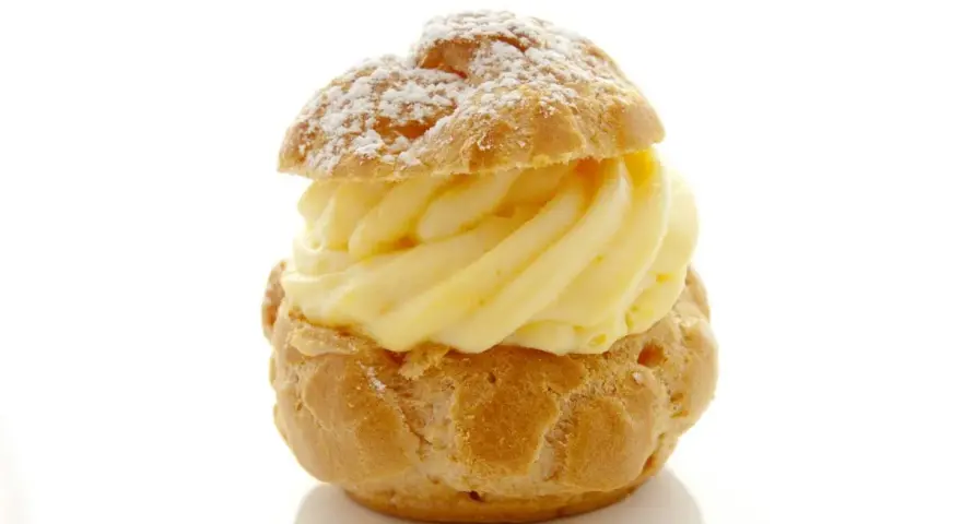 Un déliceux chou à la crème, saupoudré de sucre glace, avec une généreuse garniture de crème pâtissière onctueuse.