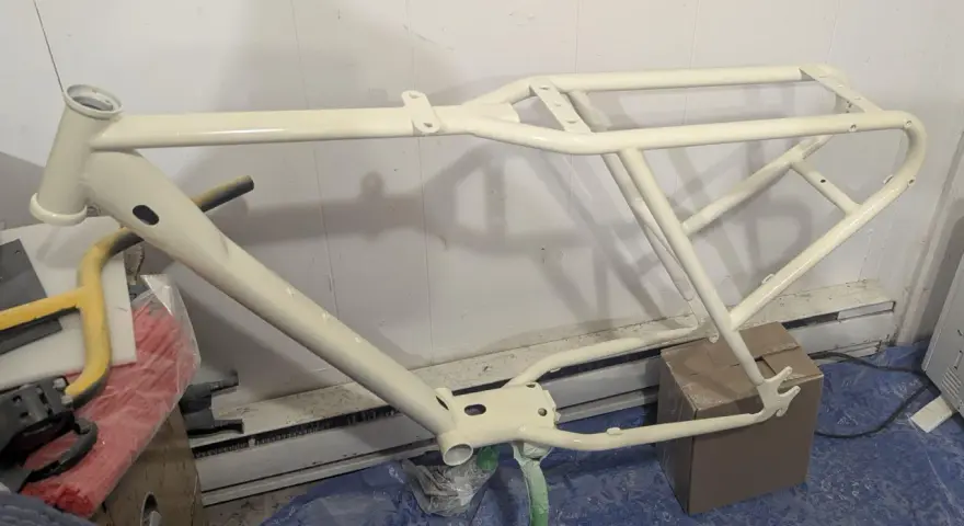 Nyligen sprayad cykelram i en ljusgul nyans, redo för nya äventyr.