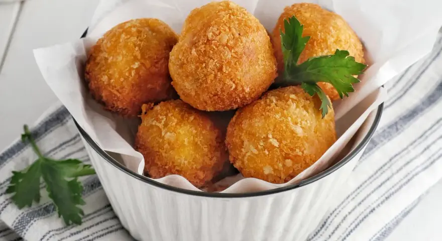 Knusprige Bitterballen, perfekt für ein leckeres Bitterballen Rezept. Serviert in einer Schüssel mit Petersilie.