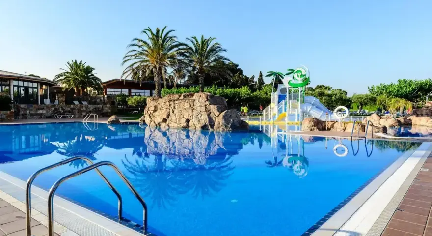 Basen w Estival Eldorado Resort z palmami i zjeżdżalniami wodnymi. Idealne miejsce na letni relaks.