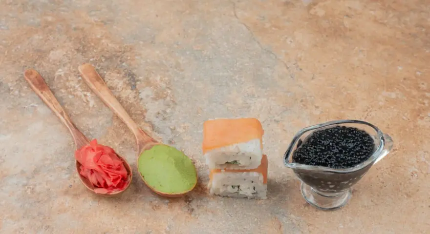 Na łyżkach imbir marynowany właściwości, zielone wasabi, sushi z łososiem i czarny kawior.