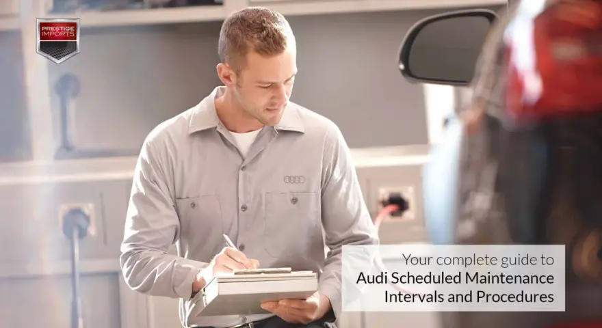Mechanik z logo Audi na koszulce notuje szczegóły w dokumencie. Twój kompletny przewodnik po **Audi plan serwisowy**.