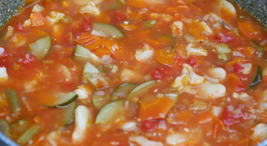 Gęsta, aromatyczna zupa jarzynowa, przypominająca włoskie minestrone, z kawałkami marchewki, cukinii i kalafiora w pomidorowym sosie.