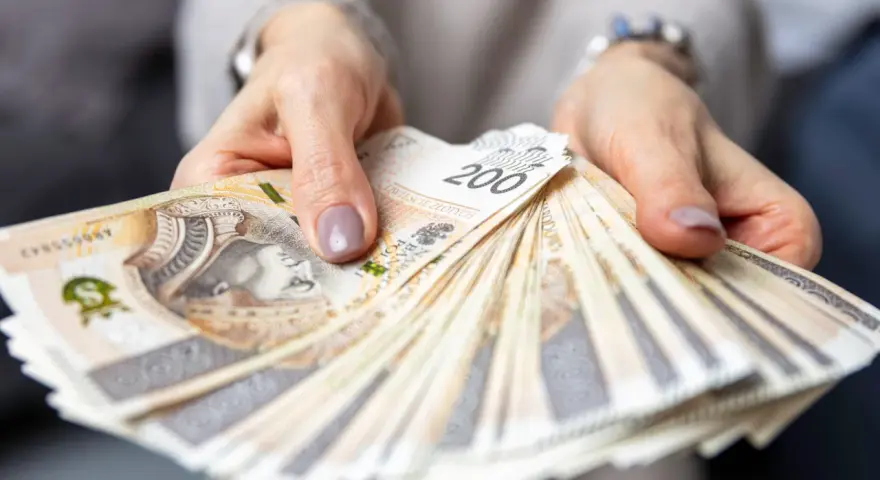Dłonie trzymające plik banknotów 200 zł. Pytanie o to, ile zarabia hotelarz, często wiąże się z takimi widokami.