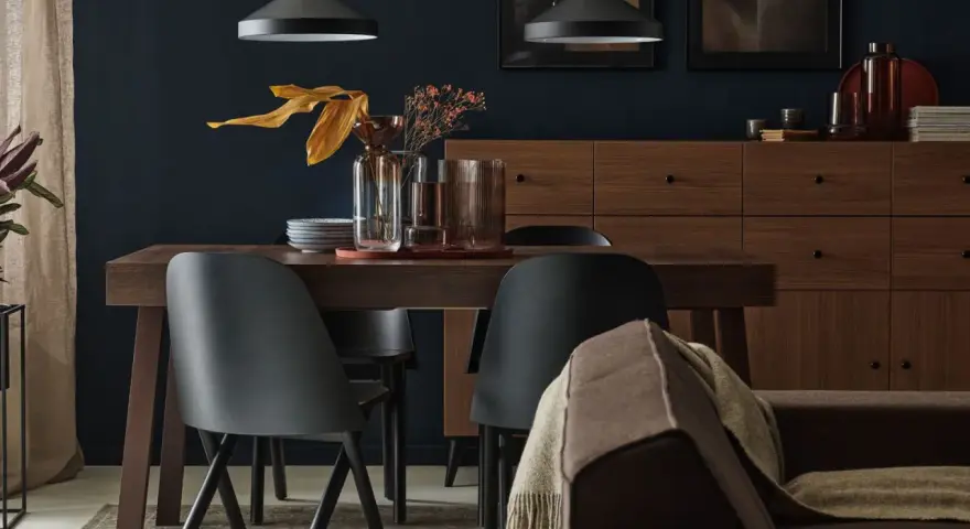 Ciemny brąz mebli i kanapy tworzy przytulną bazę. Zastanawiasz się, jaki kolor pasuje do brązu? Tutaj widzimy, że czerń i złoto dodają elegancji.