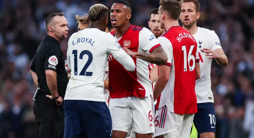 Piłkarze Arsenalu i Tottenhamu w gorącej dyskusji z sędzią. To właśnie co to są derby w piłce nożnej – mecze pełne emocji i napięcia.