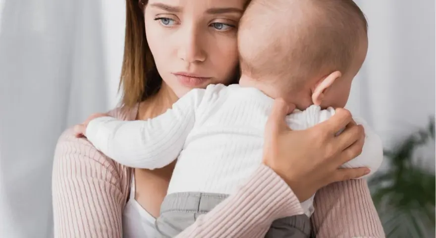 Traurige Mutter hält ihr Baby. Ihre Augen spiegeln eine tiefe Enttäuschung wider, vielleicht gender disappointment.