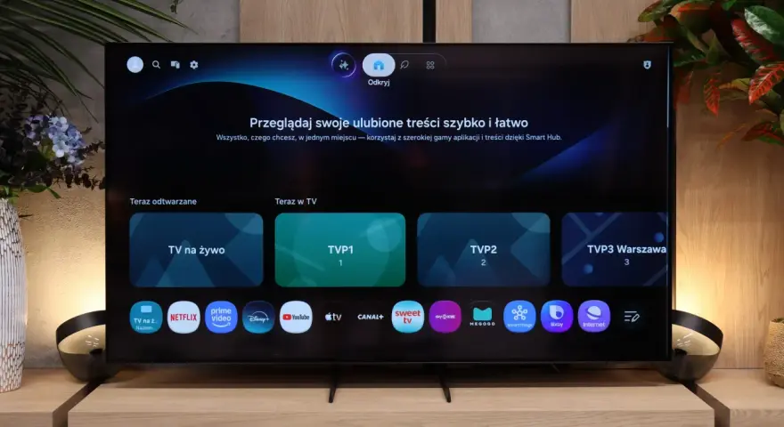 Telewizor z interfejsem Smart Hub. Widoczne aplikacje: TVP1, TVP2, Netflix, Prime Video, Disney+, YouTube.