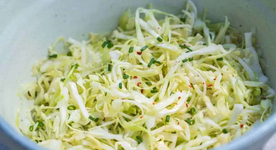 Frischer Spitzkohlsalat, garniert mit Schnittlauch und Chiliflocken. Ein einfaches Rezept für jeden Tag.