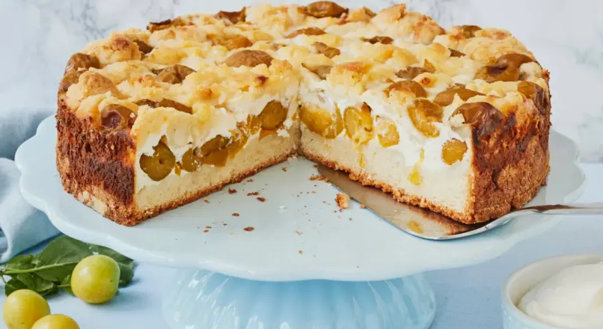 Saftiger Mirabellenkuchen mit Streuseln und cremiger Füllung auf einer hellblauen Tortenplatte.
