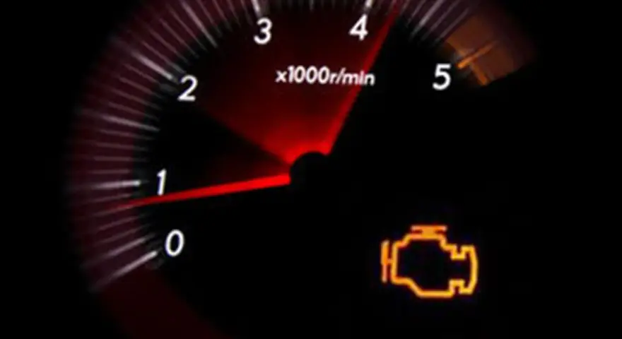 Cruscotto con spia motore accesa, indicando possibili perdita potenza motore diesel cause. Il contagiri mostra bassi giri.