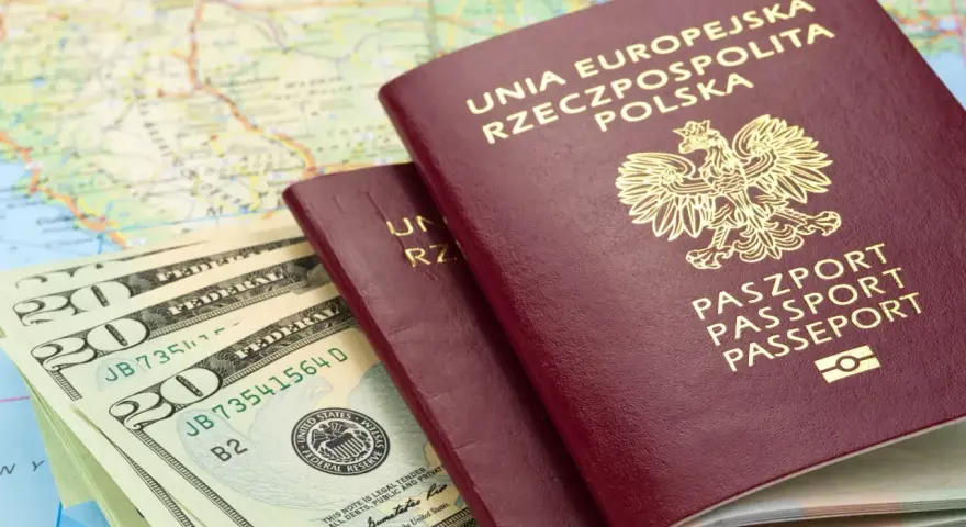 Dwa polskie paszporty, banknoty dolarowe i mapa. Czy do Rumunii potrzebny jest paszport? Tak, jeśli nie jesteś obywatelem UE.