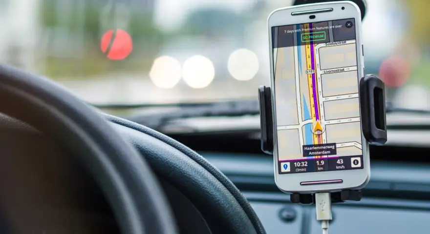 Uchwyt na telefon w samochodzie z nawigacją. Pokazuje trasę w Amsterdamie, jak zamontować uchwyt na telefon w samochodzie.