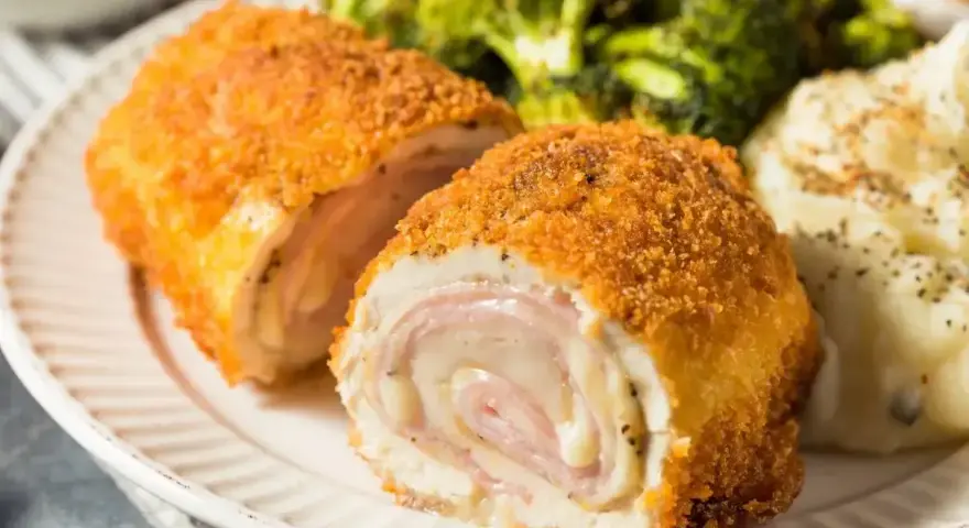 Kotlet de volaille kontra kotlet cordon bleu: złociste, panierowane rolady z kurczaka z serem i szynką, podane z puree i brokułami.