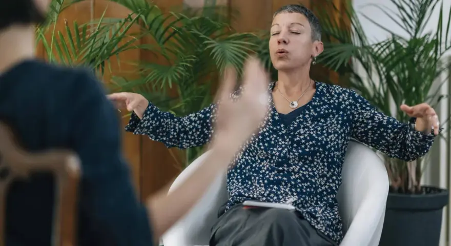 Kobieta z zamkniętymi oczami i wyrazem ulgi na twarzy, ćwicząca oddech, by poradzić sobie z dusznosciami nerwicowymi.