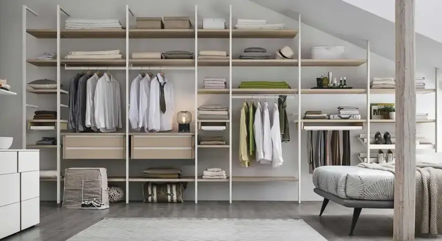 Un'idea per progettare cabina armadio: scaffali a vista con abiti appesi, cassetti e accessori.