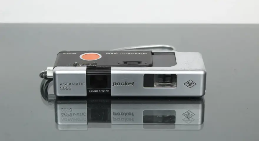Srebrny aparat Agfamatic 3008 z napisem "pocket" i logo Agfa. Idealny do uchwycenia wspomnień.