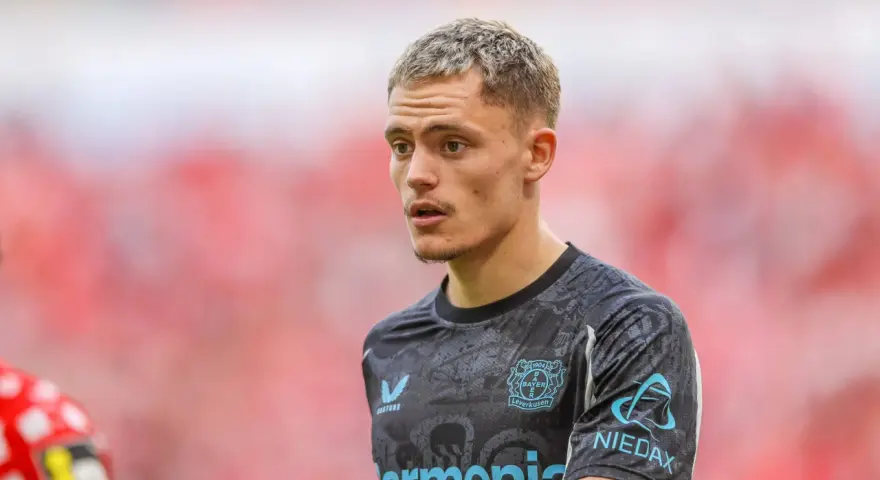 Młody piłkarz Florian Wirtz w koszulce Bayer Leverkusen, skupiony na boisku.