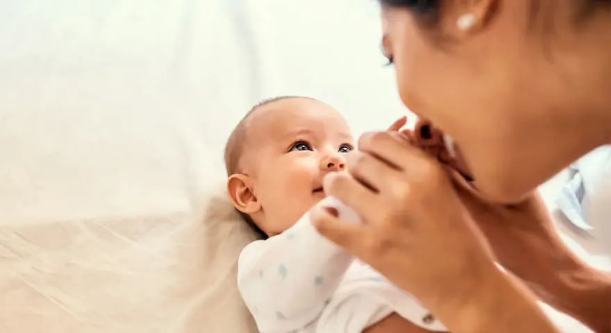 Mama czule głaszcze niemowlę, które wpatruje się w nią z zaciekawieniem. Choć ma dopiero kilka miesięcy, już widać, że to **3 letnie dziecko nie reaguje na imię**, co martwi rodziców.