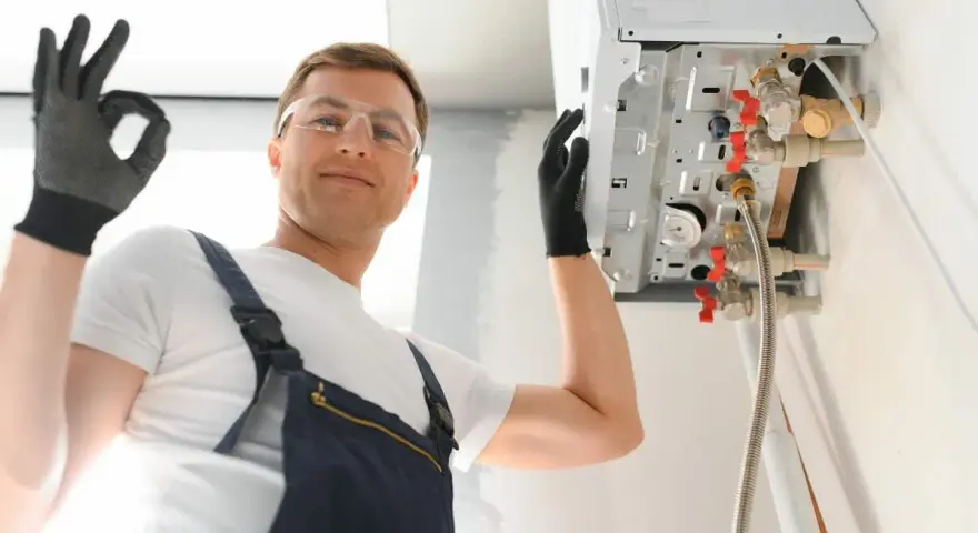 Installazione caldaia a condensazione risparmio energetico. L'installatore fa il segno OK.