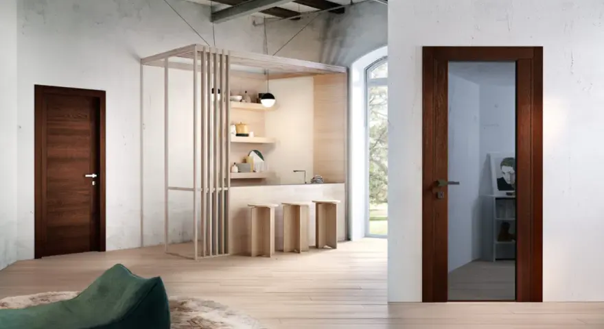 Porta in legno wenge colore, con maniglia in metallo, in un ambiente moderno con cucina a vista e pouf verde.
