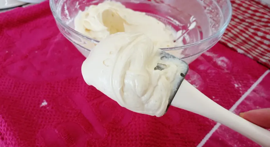 Crème onctueuse de mascarpone sur une spatule, prête pour une délicieuse recette.