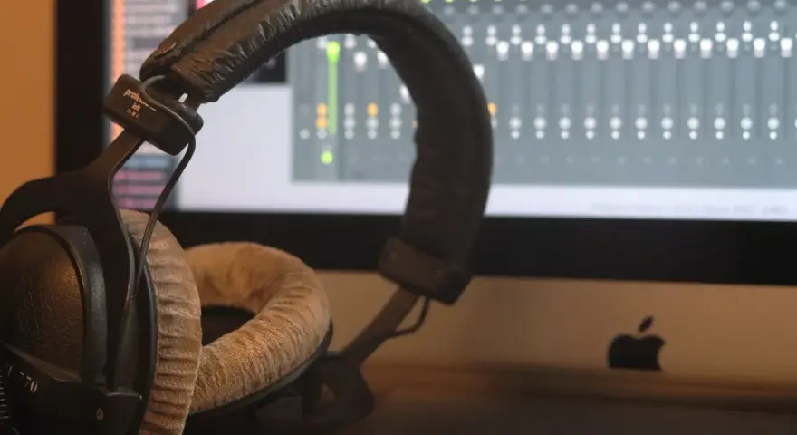 Słuchawki studyjne na tle ekranu z mikserem. Idealne do tworzenia muzyki w domowym studio nagrań.
