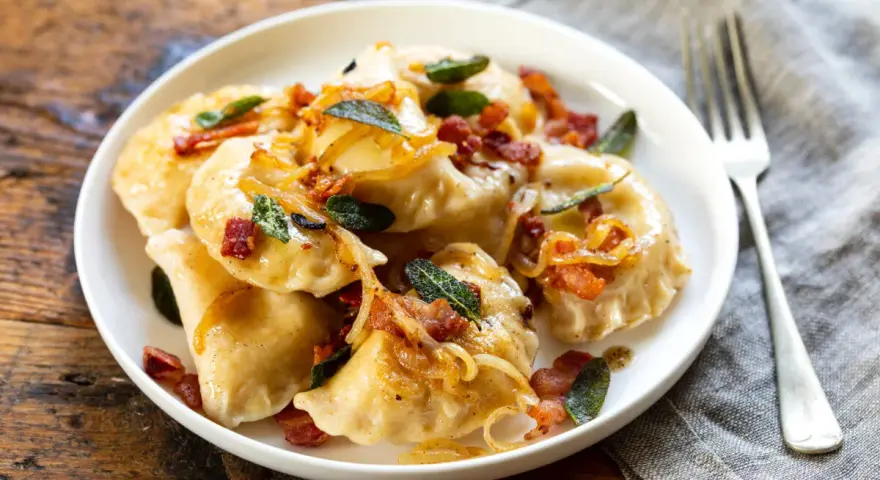 Pyszne pierogi z boczkiem i cebulką. Dowiedz się, ile gotować mrożone pierogi, by były idealne.