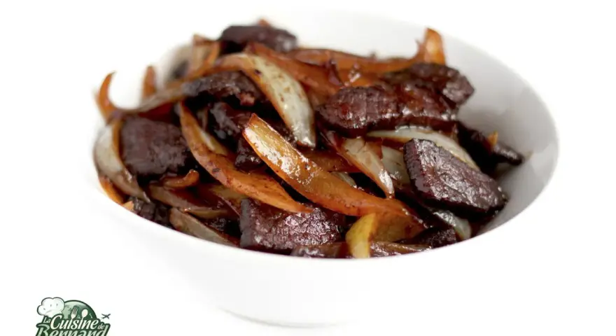 Un délicieux sauté de bœuf aux oignons caramélisés, servi dans un bol blanc. Un plat savoureux et réconfortant.
