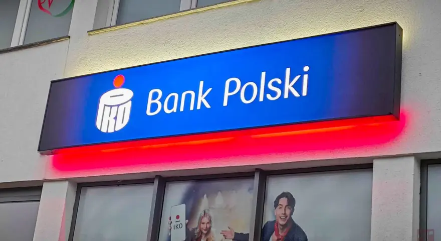 Reklama PKO Bank Polski z hasłem "kiedy nowe lokaty w pko bp". Jasny neon z logo banku i czerwone podświetlenie.