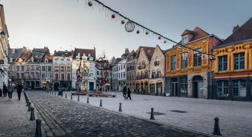 La Place du Théâtre à Lille, ornée de décorations de Noël, révèle les plus belles rues du Vieux-Lille avec ses façades colorées et pavées.