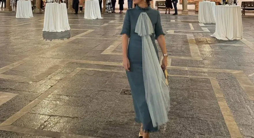 Elegante mujer con vestido azul claro y velo, lista para los Premios Princesa de Asturias.